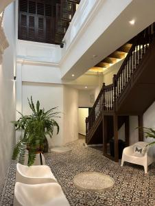 a living room with a staircase and a plant at The Magazine Boutique Hotel in George Town