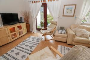 a living room with a couch and a tv at Albert's Den in Falmouth