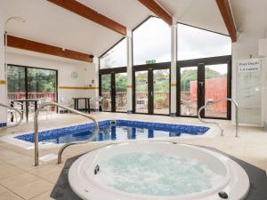 a large pool with a hot tub in a building at Albert's Den in Falmouth