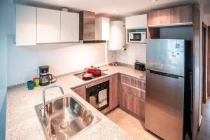 a kitchen with a sink and a stainless steel refrigerator at Dpto Bombal Patricias Mendocinas in Godoy Cruz