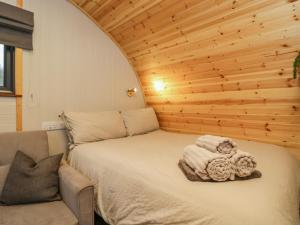 Un dormitorio con una cama y una silla con toallas. en Forest, en Dalton-in-Furness