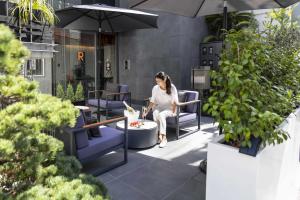 a woman sitting in a chair on a patio at Kamo Residences by Reflections in Kyoto