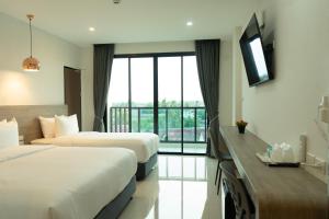 a hotel room with two beds and a window at Mountain&Sea Hotel Prachuap in Prachuap Khiri Khan