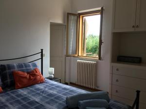 - une chambre avec un lit doté d'une couverture bleue et d'une fenêtre dans l'établissement Casa RODA Umbria 1Km da Toscana, à Castiglione del Lago