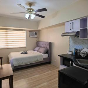 - une chambre avec un lit et un ventilateur de plafond dans l'établissement Avida Davao by davaobnb & Lemonique Homes, à Davao