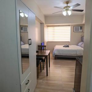 1 dormitorio con 2 camas, espejo y mesa en Avida Davao by davaobnb & Lemonique Homes, en Davao City
