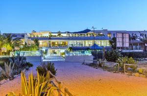un grande edificio con molte piante di fronte di Abitare in Vacanza a La Caletta