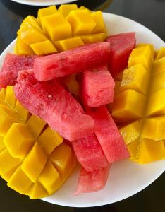 a plate of fruit with watermelon and mangoes at Bella Villa Coron in Coron