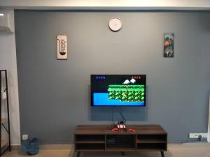 ein Wohnzimmer mit einem TV an einer blauen Wand in der Unterkunft Studio 2-4pax/2mins LRT/Netflix/YSW Homes in Subang Jaya