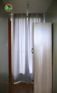 a door to a window with a white curtain at Mamay's Homestay in Tagbilaran City