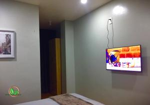 a room with a tv on a wall with a bed at Mamay's Homestay in Tagbilaran City