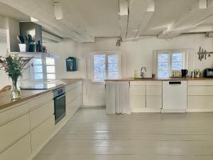 a large kitchen with white cabinets and a sink at A Charming and Beautiful Oasis in the Heart of Copenhagen in Copenhagen