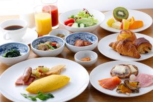 a table with plates of food and bowls of food at Hotel Okura Fukuoka in Fukuoka