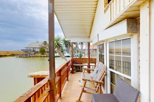 a porch of a house with two chairs and the water at Oyster Drive Bungalow in Port Isabel