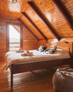 ジャブリャクにあるWooden house IRISの窓付きの木製の部屋の大型ベッド1台