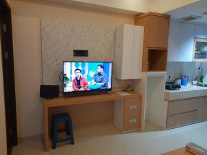 a television sitting on a table in a kitchen at Apartemen Uttara with Mountain View City Center in Kejayan