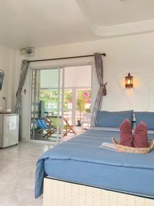 1 dormitorio con cama azul y balcón en Winnerview Zone B, en Koh Larn