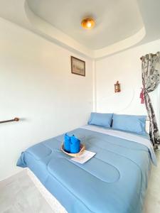 ラン島にあるWinnerview Zone Bのプレート付きの客室の青いベッド1台分です。
