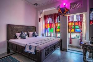 a bedroom with a bed and stained glass windows at Soham Haveli - A Lake Facing Stay in Udaipur in Udaipur