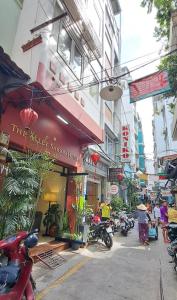 une rue dans une ville asiatique avec des motos garées à l'extérieur dans l'établissement The Alley Saigon Hotel, à Hô-Chi-Minh-Ville