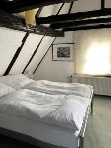 a bedroom with two white beds and a window at Ferienwohnung im 'Schmoller - Hof' in Neustadt an der Weinstraße