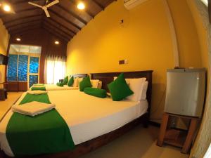 Mount Seven Holiday Inn في بيلهول اويا: غرفة نوم بسريرين مع وسائد خضراء