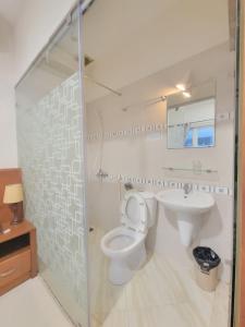 a bathroom with a toilet and a sink and a mirror at The Alley Saigon Hotel in Ho Chi Minh City