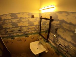 Mount Seven Holiday Inn في بيلهول اويا: حمام مع حوض وغيوم مدهونة على الحائط