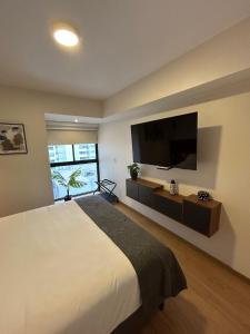 1 dormitorio con 1 cama grande y TV de pantalla plana en Stylist and modern 1BR in Lima, en Lima
