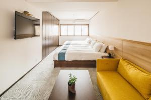 a hotel room with a bed and a couch at RESI STAY Gion in Kyoto
