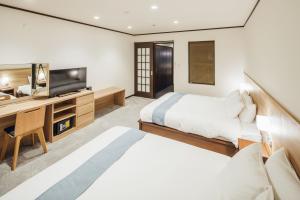 a bedroom with a bed and a desk and a television at RESI STAY Gion in Kyoto