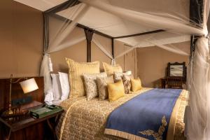 德拉敦Aalia Jungle Retreat and Spa, Bandarjudh, Haridwar - Araiya Anthology的一间卧室配有一张带黄色枕头的天蓬床