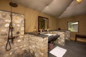 德拉敦Aalia Jungle Retreat and Spa, Bandarjudh, Haridwar - Araiya Anthology的大型石质浴室设有水槽和淋浴