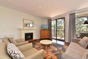 un soggiorno con divano e camino di Villa 3br Fiano Villa located within Cypress Lakes Resort a Pokolbin