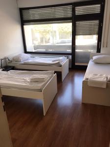 シュトゥットガルトにあるHotel Mautner Airport und Messehotelのベッド3台と窓が備わる客室です。