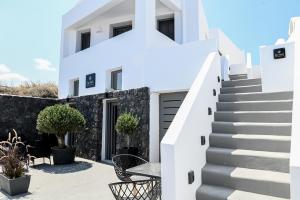 a white house with stairs and a table at Villa Eleana in Monolithos