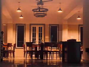 una sala da pranzo con tavolo, sedie e lampadario pendente di The Aravali Kumbhalgarh a Kumbhalgarh