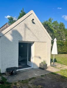 eine Garage mit offener Tür und einem Regenschirm in der Unterkunft Studio avec grand jardin + parking in Seraincourt