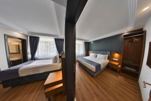 um quarto de hotel com duas camas e uma janela em BUKAVİYYE HOTEL em Ancara