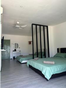 um quarto com 2 camas e uma ventoinha de tecto em Casa Lena em Cherating