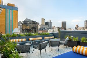a rooftop patio with chairs and a view of the city at The Carrington Aparthotel by Totalstay in Cape Town