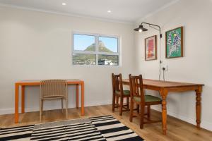a dining room with a wooden table and chairs at The Carrington Aparthotel by Totalstay in Cape Town