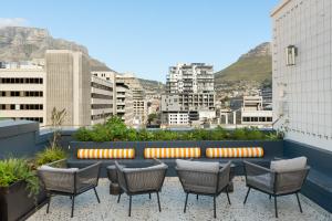 a patio with chairs and a bench on a building at The Carrington Aparthotel by Totalstay in Cape Town