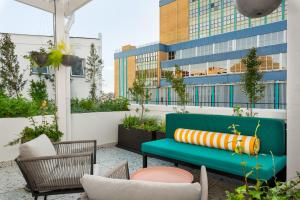 a rooftop patio with a green bench and chairs at The Carrington Aparthotel by Totalstay in Cape Town