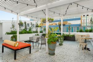 an outdoor patio with a bench and tables and chairs at The Carrington Aparthotel by Totalstay in Cape Town