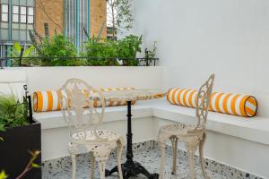 a table and two chairs on a balcony at The Carrington Aparthotel by Totalstay in Cape Town