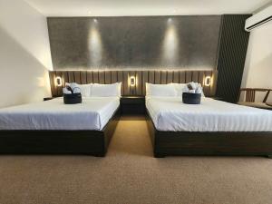 2 Betten in einem Hotelzimmer mit weißer Bettwäsche in der Unterkunft Room in M Stay Hotel - near Midori, Swissotel, Marriott, Widus, Hann 