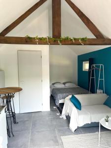 2 Betten in einem Zimmer mit blauen Wänden und einem Tisch in der Unterkunft Studio avec grand jardin + parking in Seraincourt
