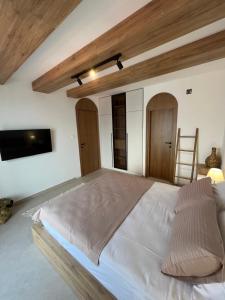 een slaapkamer met een groot bed en een televisie bij Casa Brilla in Tivat