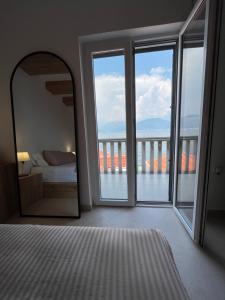 a bedroom with a mirror and a large window at Casa Brilla in Tivat
